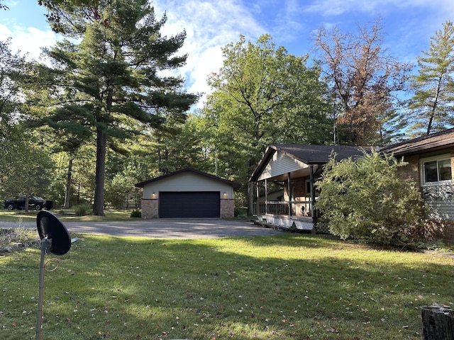 view of yard with an outbuilding, a garage, and covered porch