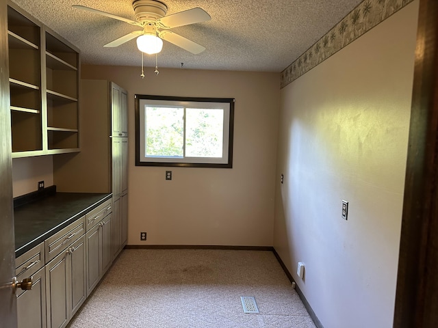 interior space featuring ceiling fan, light colored carpet, and a textured ceiling