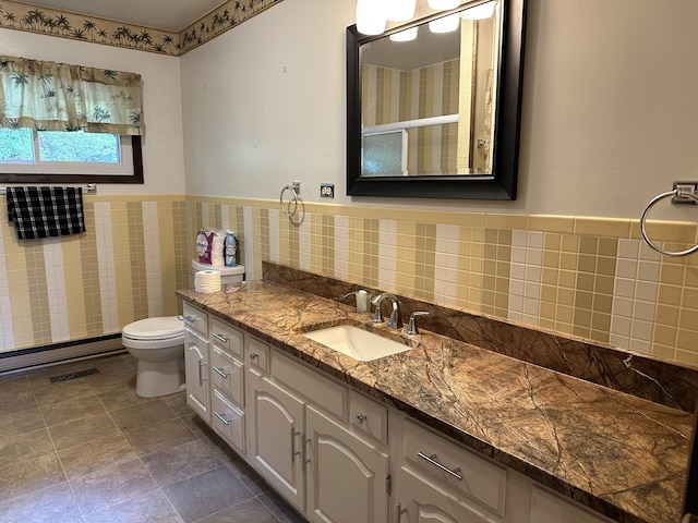 bathroom with vanity, toilet, and tile walls