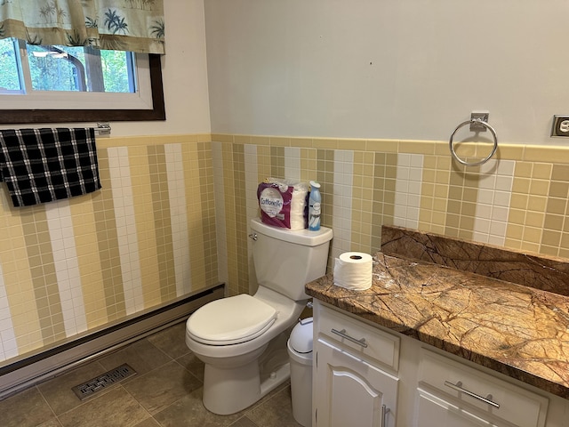 bathroom featuring tile patterned flooring, tile walls, and toilet