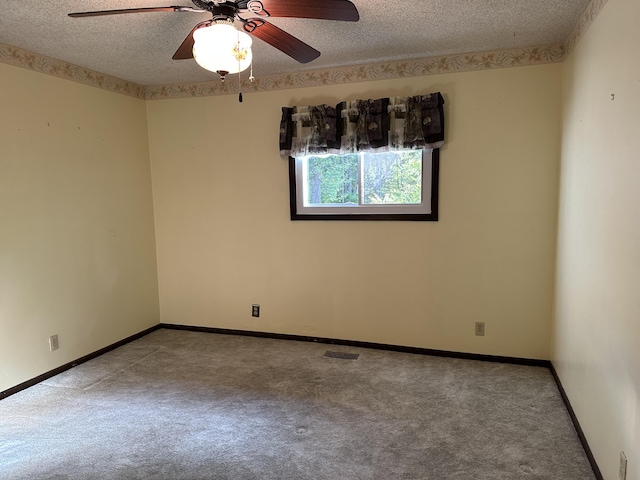 carpeted empty room featuring ceiling fan and a textured ceiling