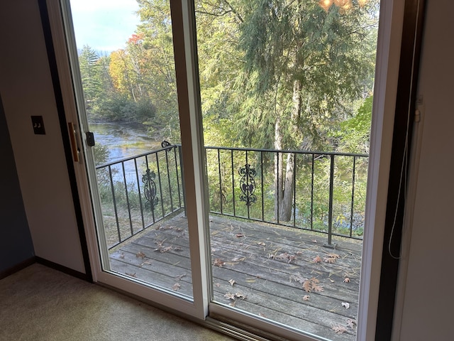 doorway featuring a water view and carpet floors