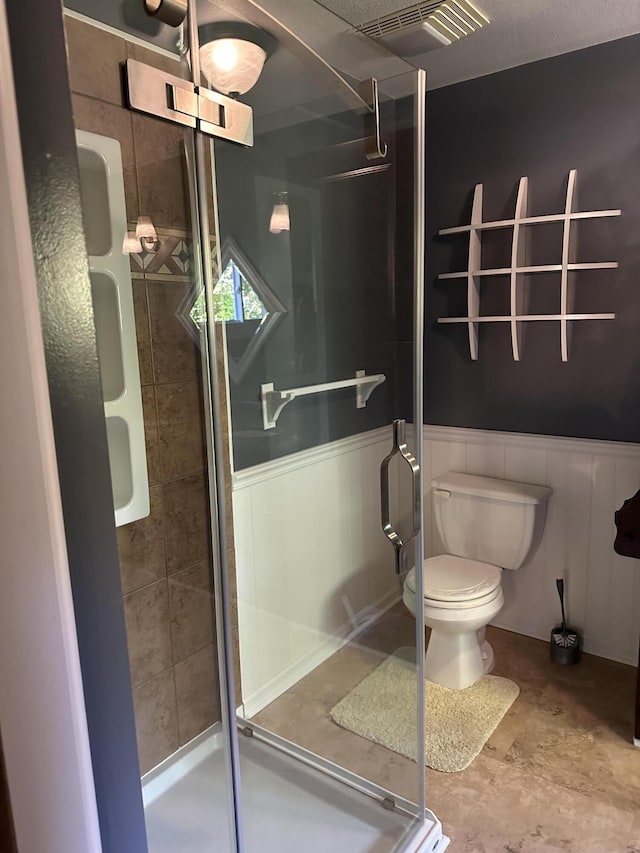 bathroom featuring walk in shower and toilet