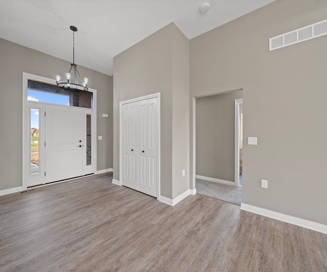 entrance foyer with light hardwood / wood-style flooring and a notable chandelier