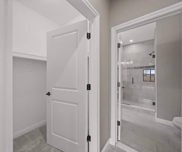 bathroom featuring a stall shower and baseboards