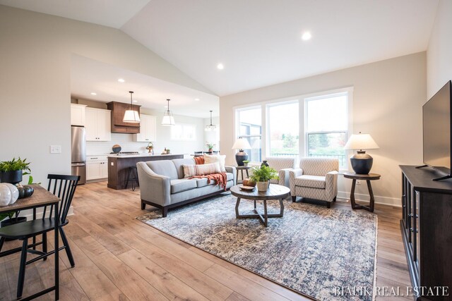 living room featuring light hardwood / wood-style floors and vaulted ceiling