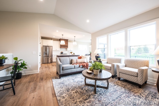 living room featuring light wood-type flooring and vaulted ceiling