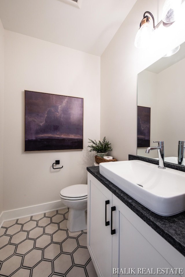 bathroom featuring tile patterned floors, vanity, and toilet