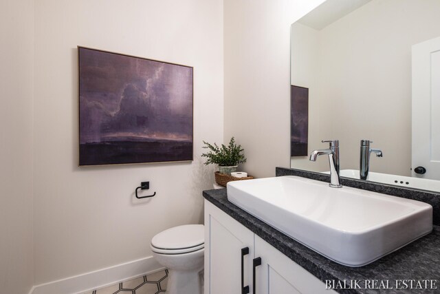 bathroom featuring toilet, vanity, and tile patterned floors