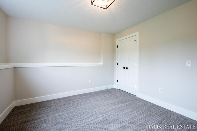 spare room featuring carpet floors and a textured ceiling