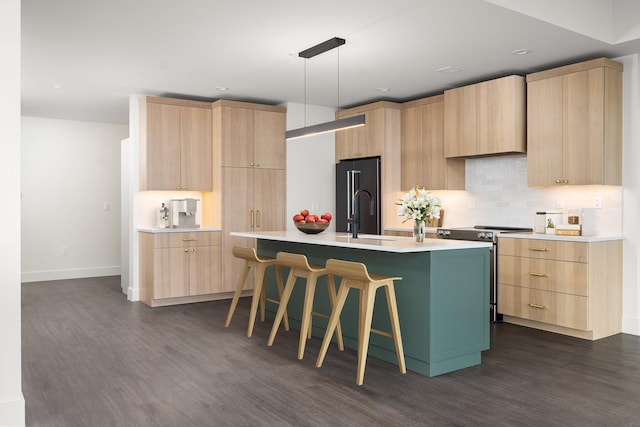 kitchen with stainless steel electric stove, an island with sink, light brown cabinetry, and dark wood-type flooring