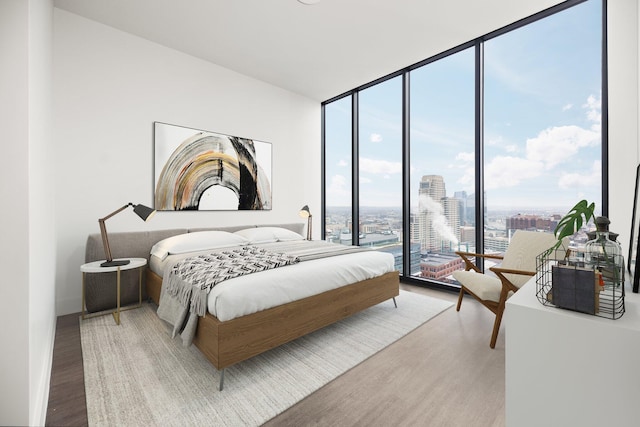 bedroom with hardwood / wood-style floors and expansive windows