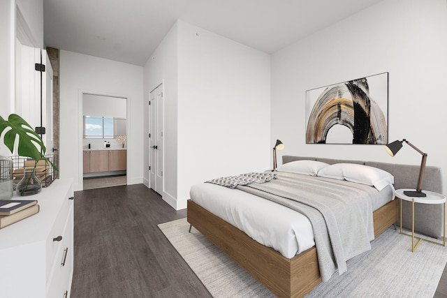 bedroom with connected bathroom and dark wood-type flooring