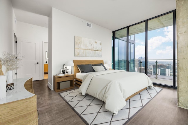 bedroom featuring access to outside, expansive windows, and light hardwood / wood-style floors