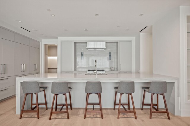 kitchen featuring sink, a breakfast bar area, a spacious island, and light wood-type flooring