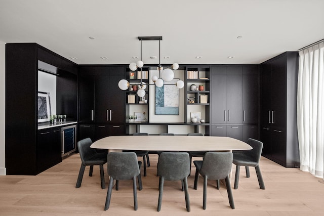 dining area with light hardwood / wood-style flooring and beverage cooler