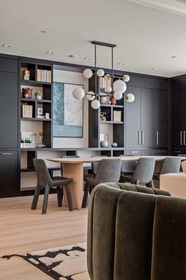 dining area with light wood-type flooring and built in desk