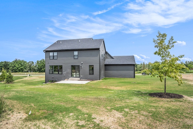 rear view of house with a patio and a lawn