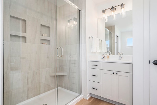 bathroom with vanity, a shower with shower door, and hardwood / wood-style flooring