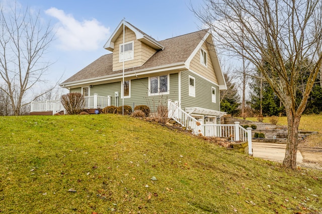 view of property exterior with a lawn and a deck