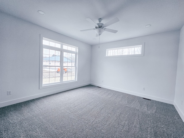 carpeted spare room featuring ceiling fan