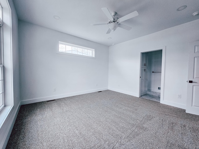 unfurnished room with ceiling fan and carpet flooring