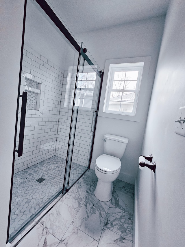 bathroom with a shower with door, tile patterned flooring, and toilet