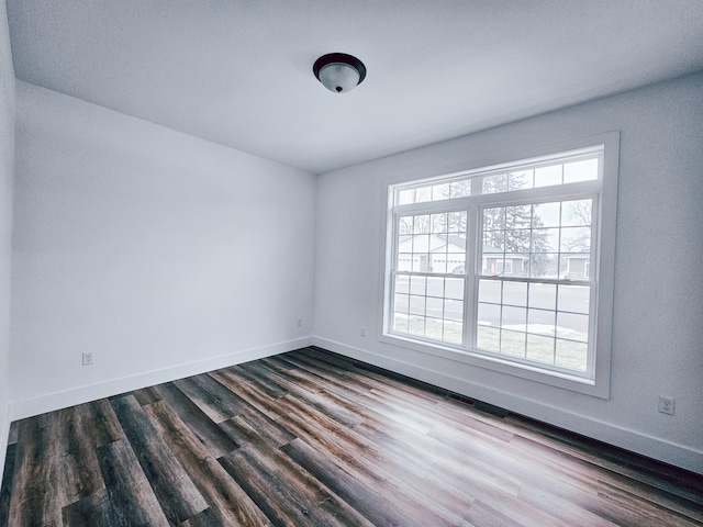 spare room with a healthy amount of sunlight and hardwood / wood-style floors