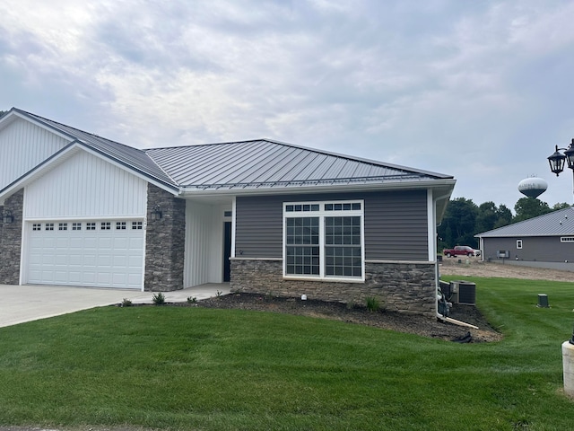 view of front of home featuring central AC, a front yard, and a garage