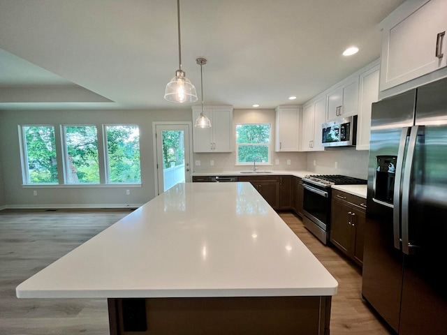 kitchen featuring a healthy amount of sunlight, stainless steel appliances, and a kitchen island