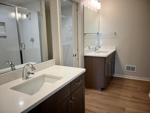 bathroom with vanity, hardwood / wood-style flooring, and a shower with shower door