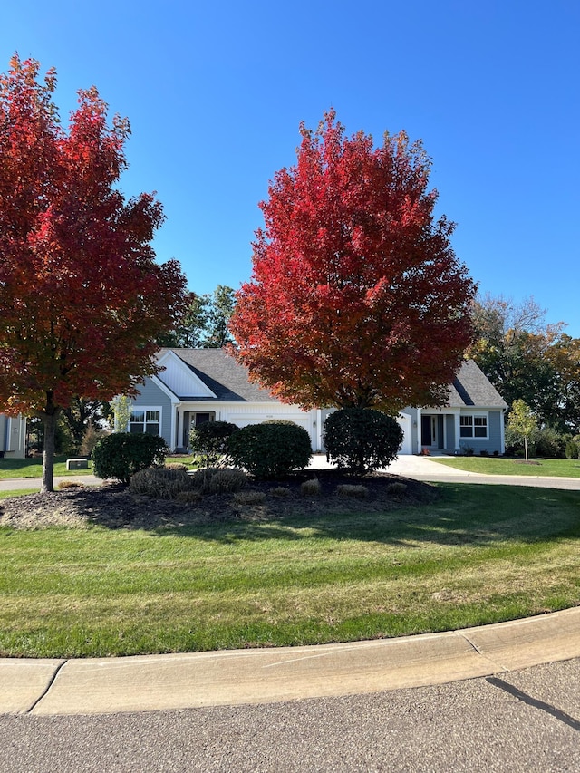 view of property hidden behind natural elements featuring a front yard