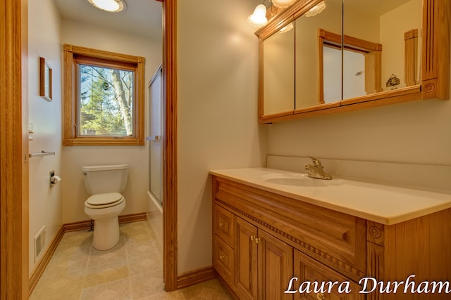 full bathroom featuring vanity, shower / bath combination with glass door, and toilet