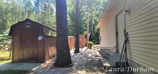 view of side of property featuring a storage shed and a patio