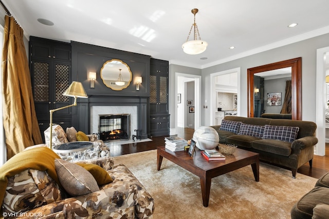 living room with a fireplace, ornamental molding, and hardwood / wood-style flooring