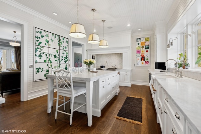 kitchen featuring white cabinetry, a center island, dark wood-type flooring, and crown molding