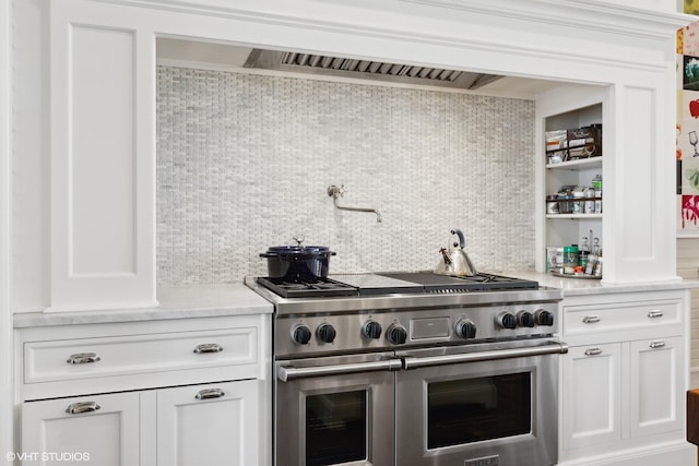 kitchen with white cabinetry, range with two ovens, and decorative backsplash