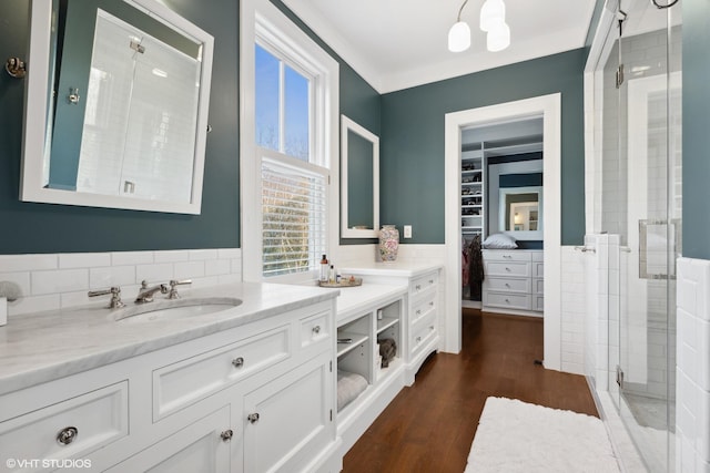 bathroom featuring hardwood / wood-style flooring, a shower with door, vanity, and a healthy amount of sunlight