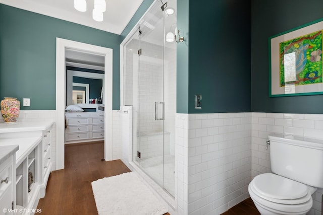 bathroom featuring tile walls, toilet, hardwood / wood-style flooring, and walk in shower