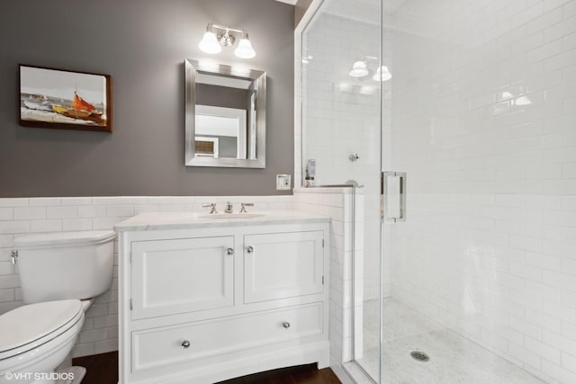 bathroom featuring wood-type flooring, an enclosed shower, vanity, tile walls, and toilet