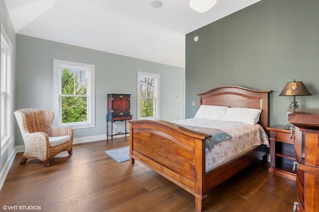 bedroom with multiple windows, vaulted ceiling, and dark hardwood / wood-style floors