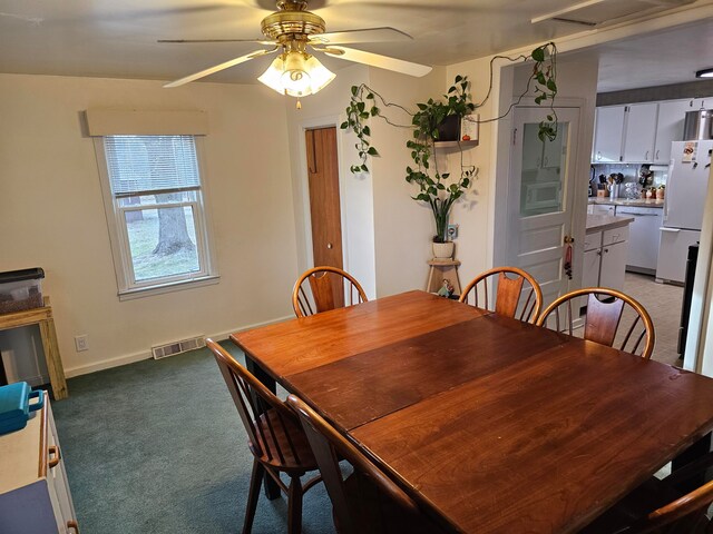 dining space with light carpet and ceiling fan