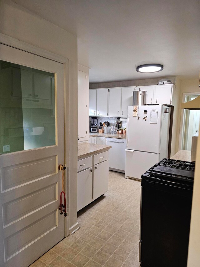 kitchen featuring white cabinets, white appliances, and light tile floors