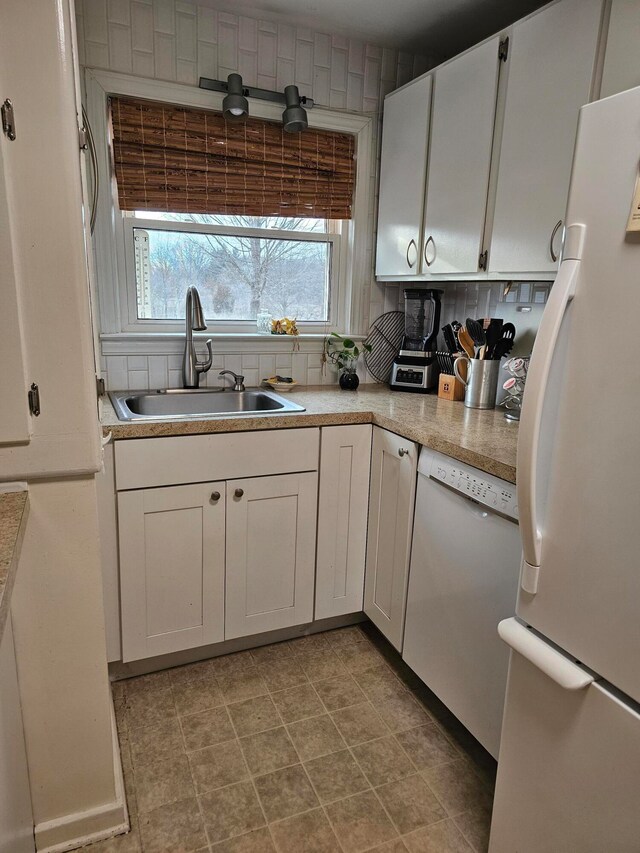 kitchen featuring light tile flooring, backsplash, white cabinets, sink, and white appliances
