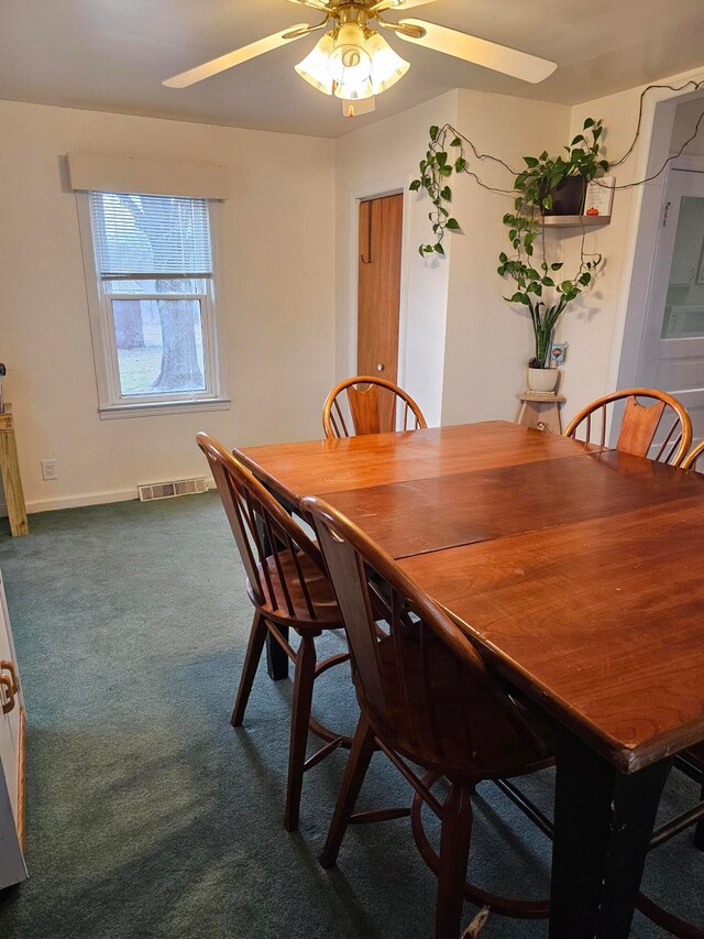 dining room featuring ceiling fan and dark colored carpet