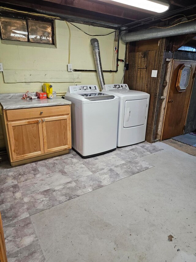 washroom with cabinets and washing machine and dryer