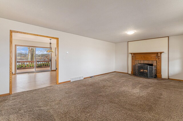 unfurnished living room featuring a fireplace and carpet