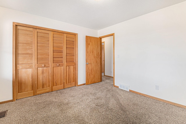 unfurnished bedroom featuring carpet flooring and a closet