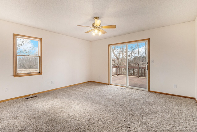 unfurnished room with a textured ceiling, ceiling fan, and carpet flooring