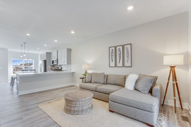 living room featuring sink and light wood-type flooring